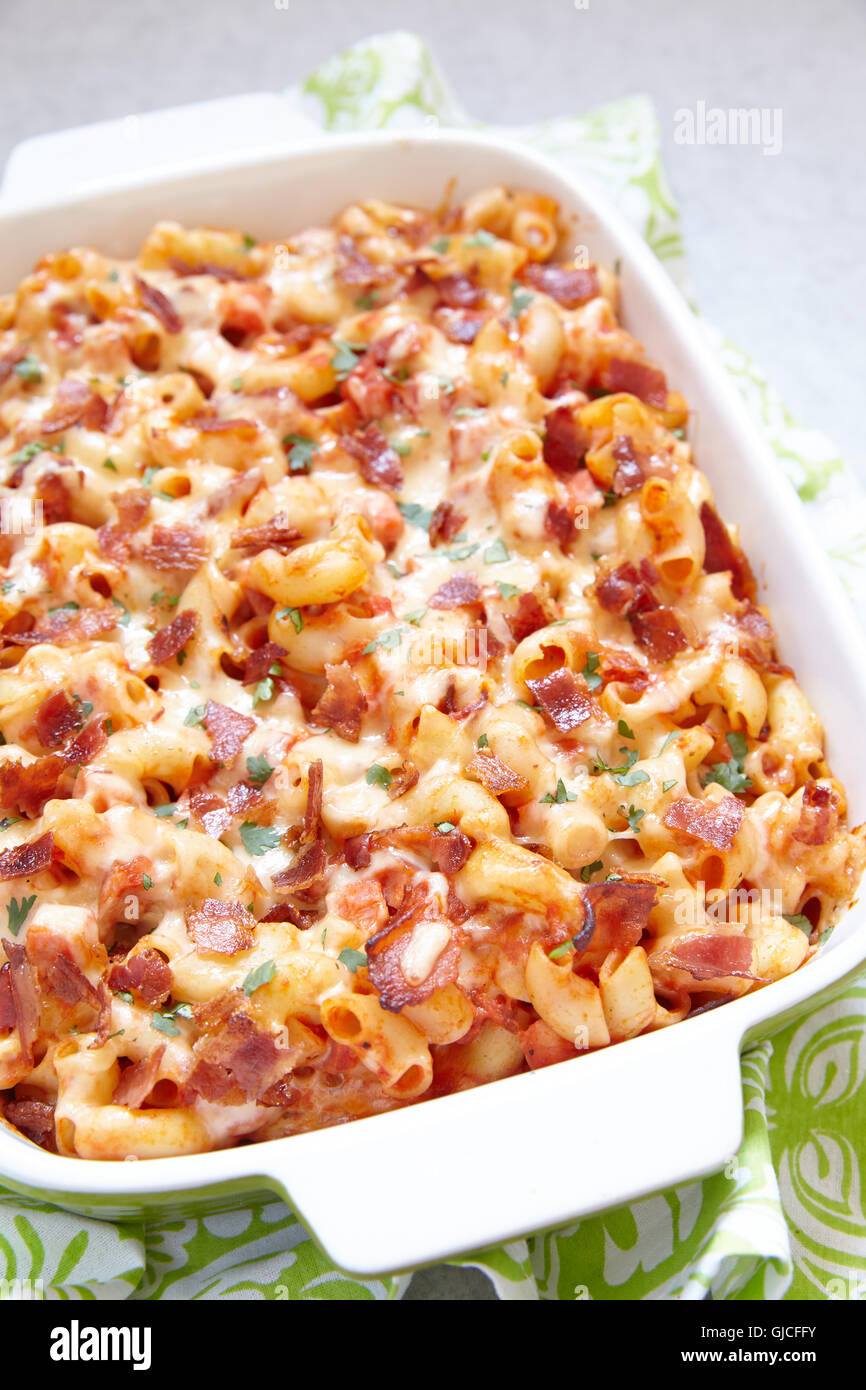 Pasta-Auflauf mit Speck, Schinken, Käse und Tomatensauce Stockfoto