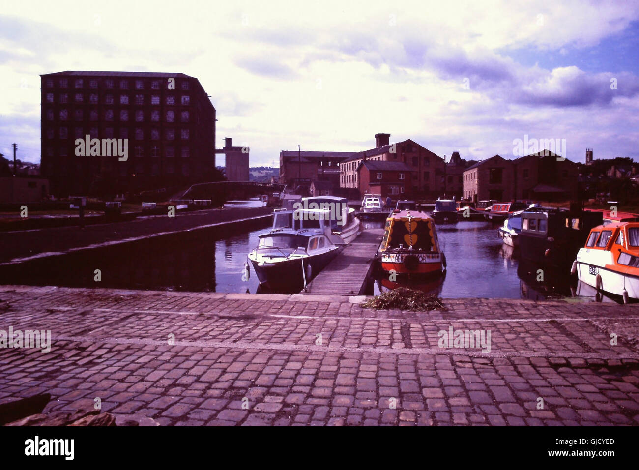 1980 blauer Himmel weiße Wolken Sommer Tagesansicht, Blick nach Westen von Karens Tag der Calder und Hebble Navigation Canal Basin Marina mit vielen Freizeitbooten, in Richtung der ehemaligen Millroyd Mill und jetzt abgerissen Victoria Mühle Komplex, Brighouse, Calderdale, West Yorkshire, Großbritannien Stockfoto