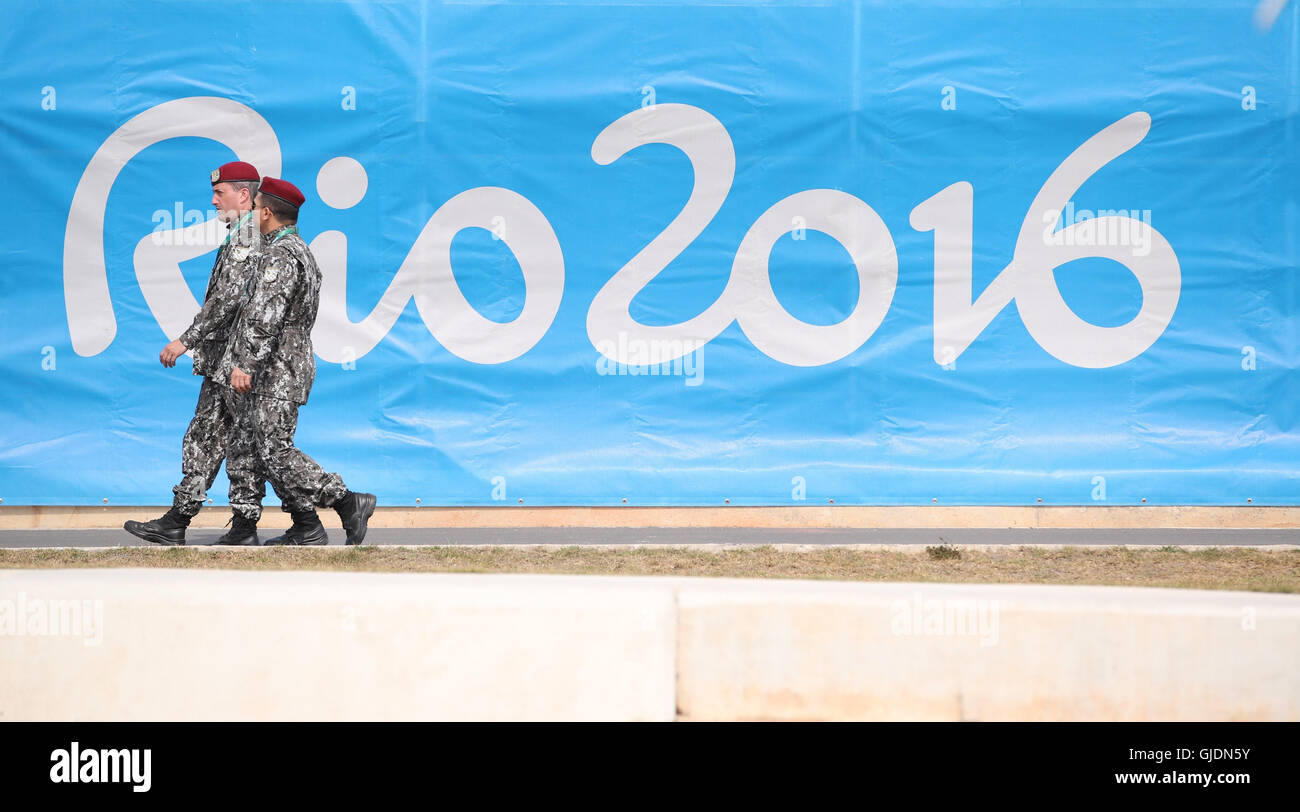 Rio De Janeiro, Brasilien. 7. August 2016. Brasilianischen Militär Soldaten geht vorbei an der offizielle Olympia-Logo Om einen Zaun in Deodoro, Rio De Janeiro, Brasilien, 6. August 2016. Olympische Spiele 2016 in Rio statt von 05 bis 21 August. während die Rio Olympischen Spiele 2016 in Rio De Janeiro, Brasilien, 7. August 2016. Foto: Friso Gentsch/Dpa/Alamy Live News Stockfoto