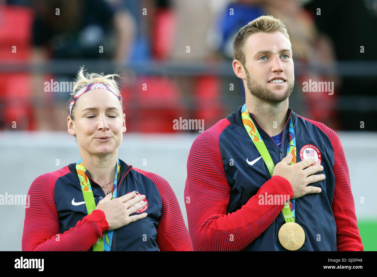 Rio de Janeiro, Brasilien 14th Aug, 2016 Bethanie Mattek-Sands und Jack Sock während der Nationalhymne als die Verwirklichung dämmerte auf den Gewinn der Goldmedaille im Olympischen Mixed Doubles Tennis Finale in Rio de Janeiro. Sie schlugen Venus Williams und Rajeev RAM. Stockfoto