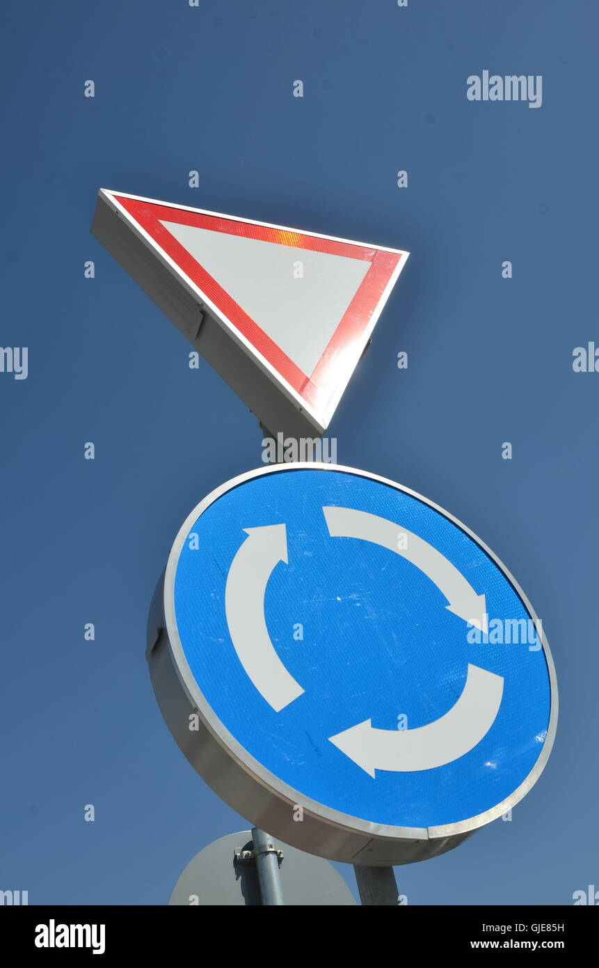 Kreisverkehr und geben unterzeichnen Weg am blauen Himmel Stockfoto