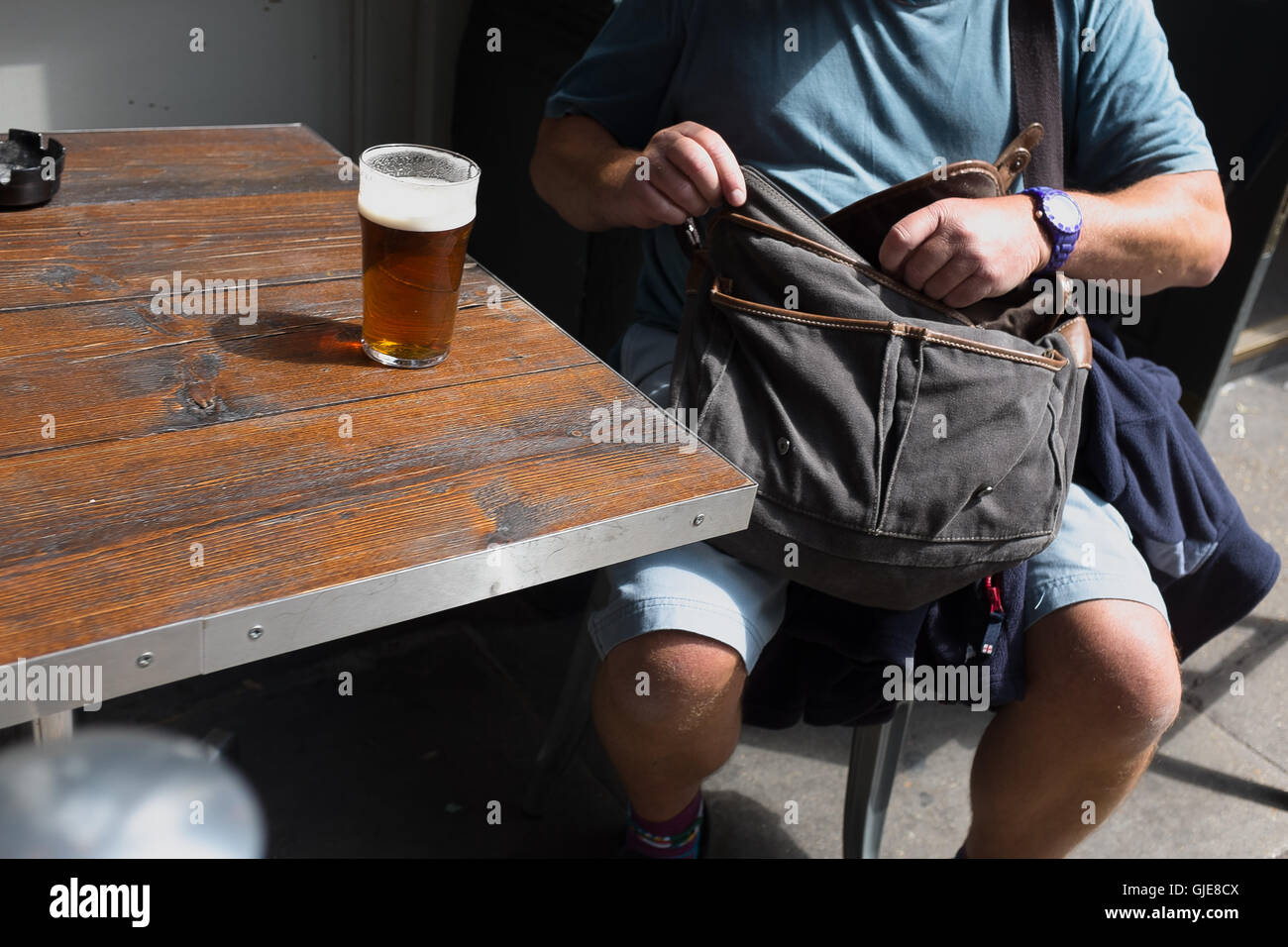 Ein Mann nimmt eine Auszeit in der Sonne für ein Pint. Stockfoto