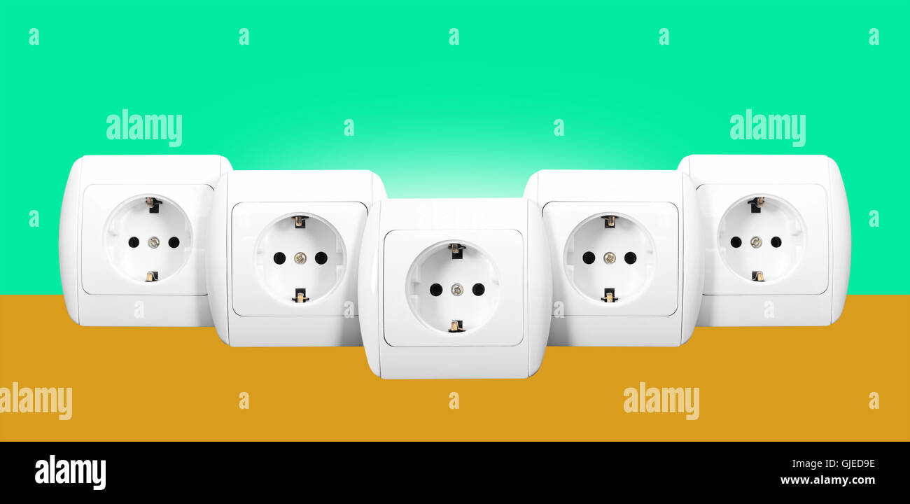 Stromnetz - die fünf weiße Steckdose mit Erdung auf einem grünen und Orangen Hintergrund. Stockfoto