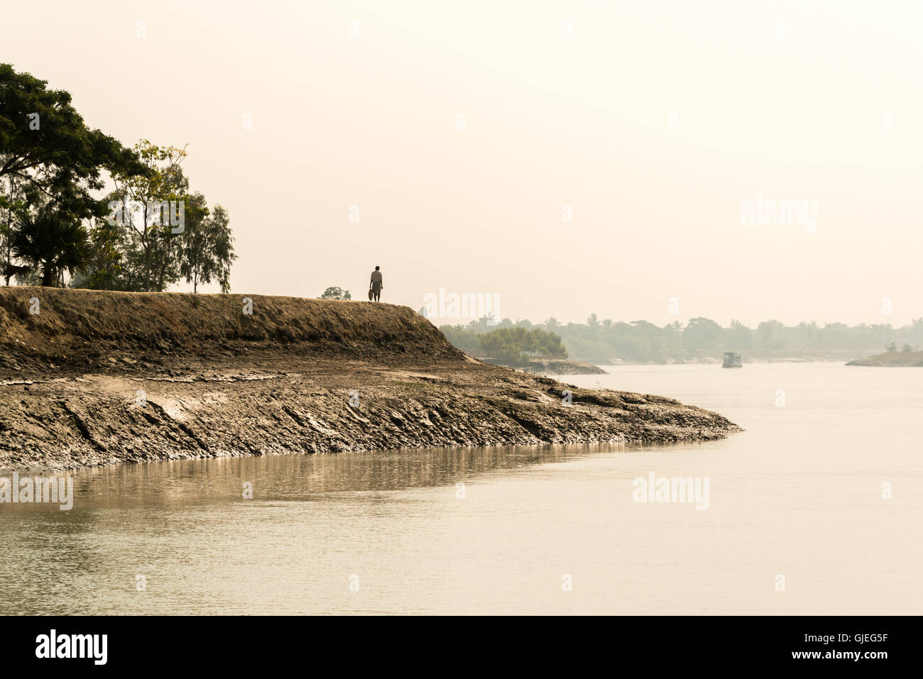 Eine Person, die auf der Kante einer schlammigen Bank in den Sundarbans National Park, West Bengal, Indien stehend Stockfoto