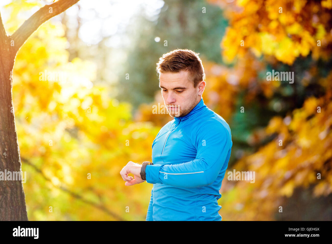 Läufer in der herbstlichen Natur Messzeit mit seiner Uhr Stockfoto