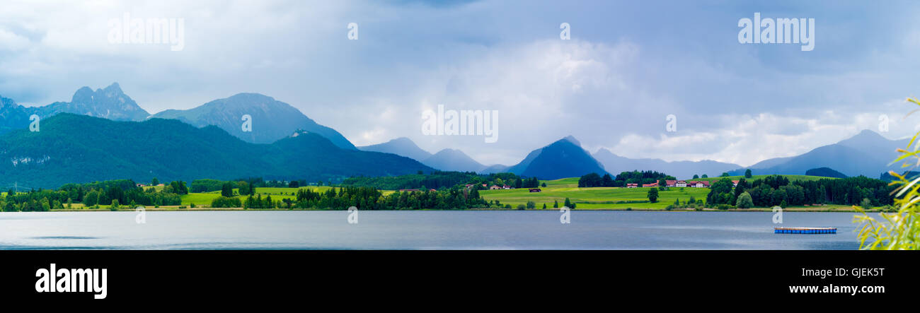 See in den deutschen Alpen mit einer Kette der Berge am Horizont. Spiegelung des Himmels im Wasser Stockfoto