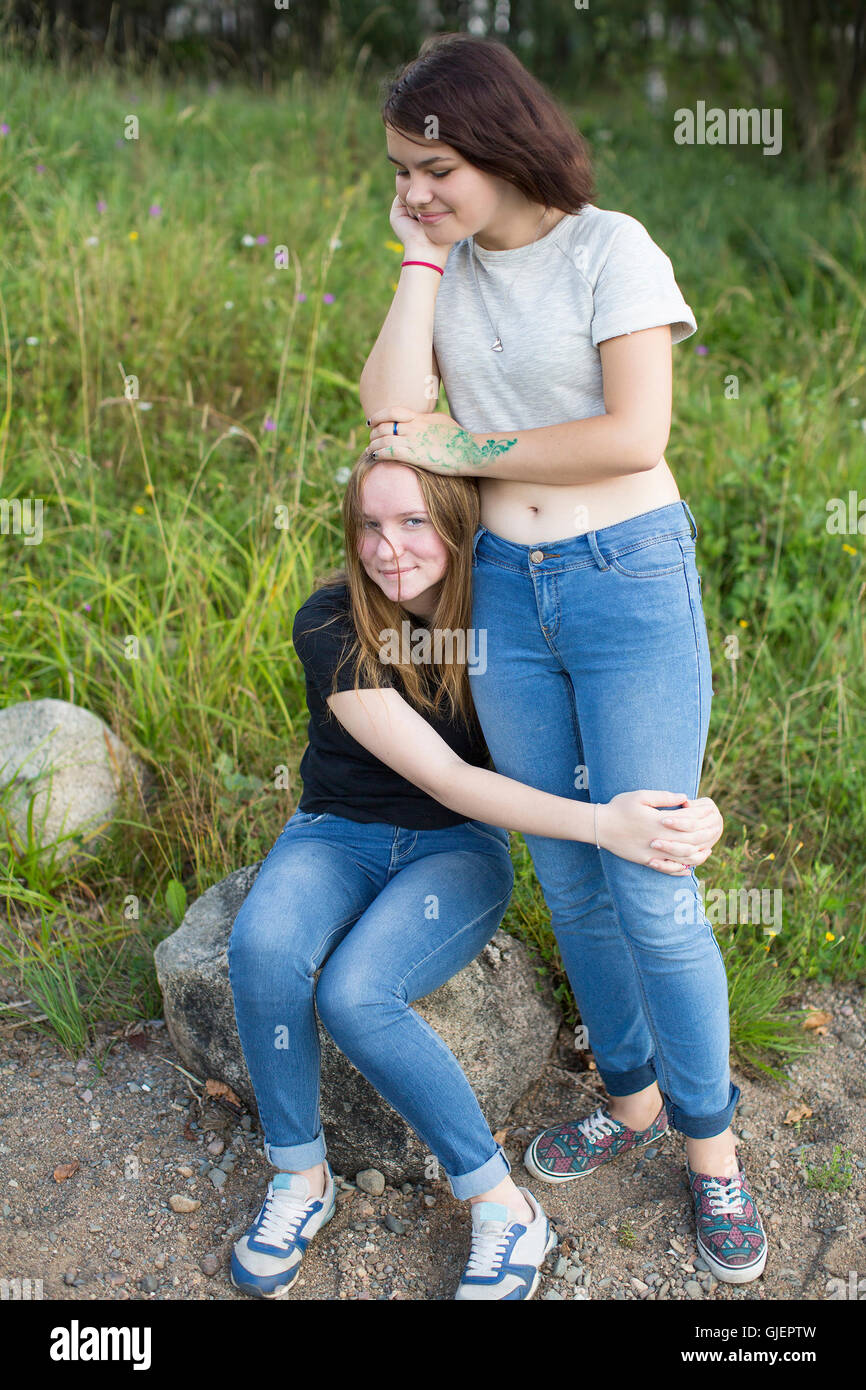 Zwei Mädchen im Teenageralter sind die besten Freunde auf der Lichtung umarmt. Stockfoto