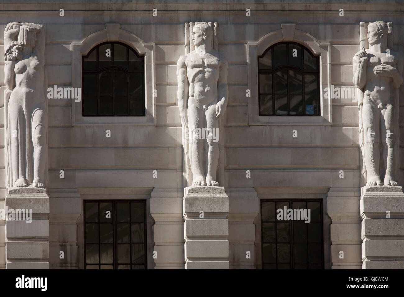 Mythischen griechischen männlichen Telamon Zahlen blicken einer weiblichen Karyatide-Skulptur an der Außenseite der Bank of England in der City of London. Stockfoto