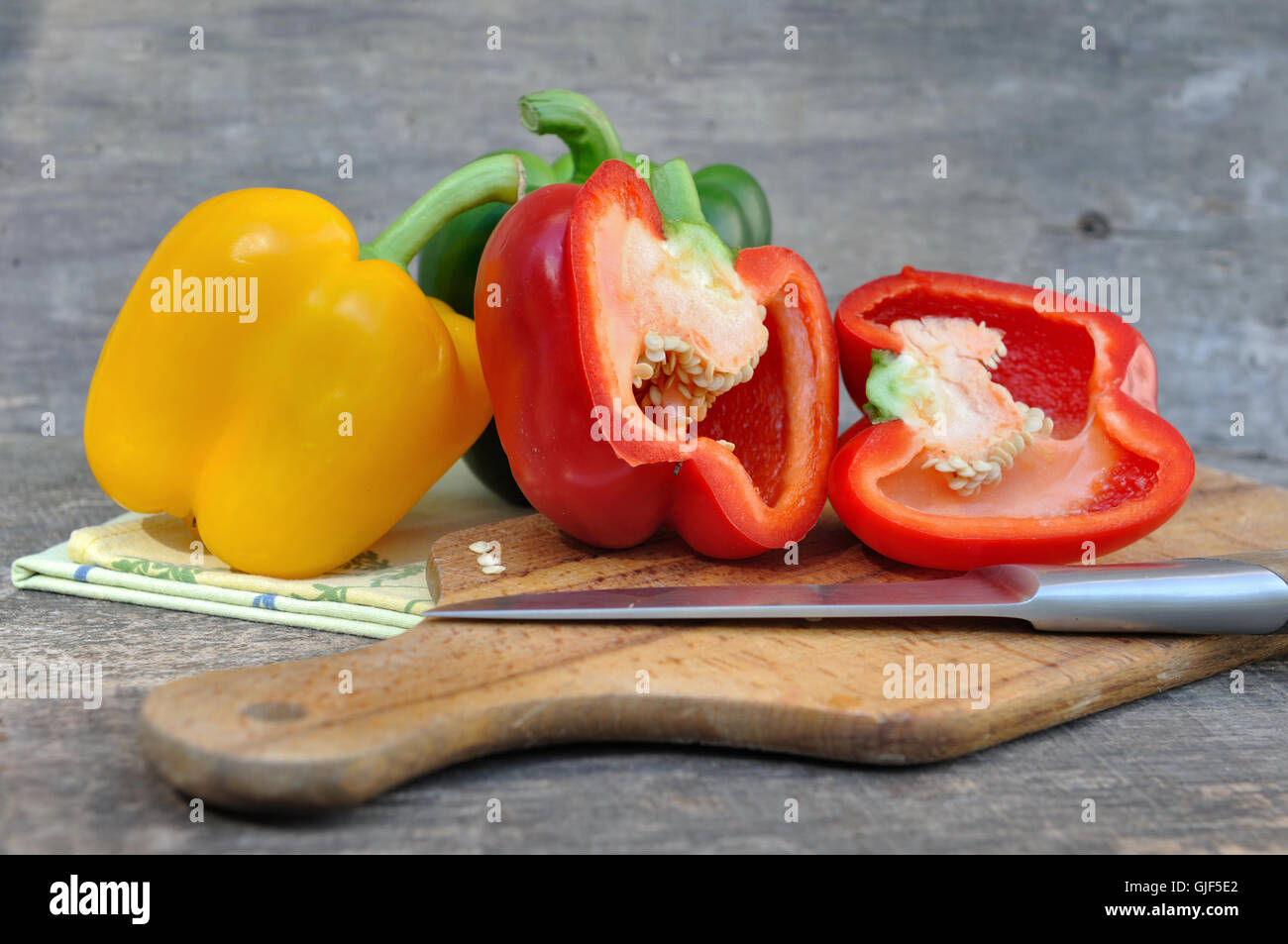 rote Paprika halbieren mit anderen an Bord mit Messer Stockfoto