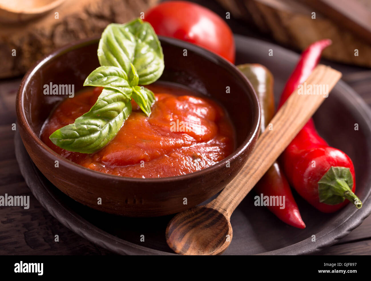 Schüssel mit Tomatensauce und Holzlöffel Stockfoto