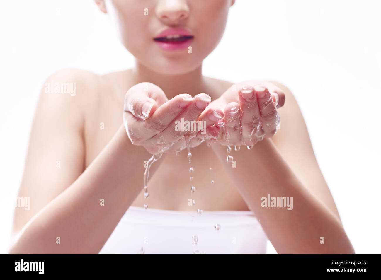 junge und schöne asiatische Frau Gesicht mit Wasser waschen. Stockfoto