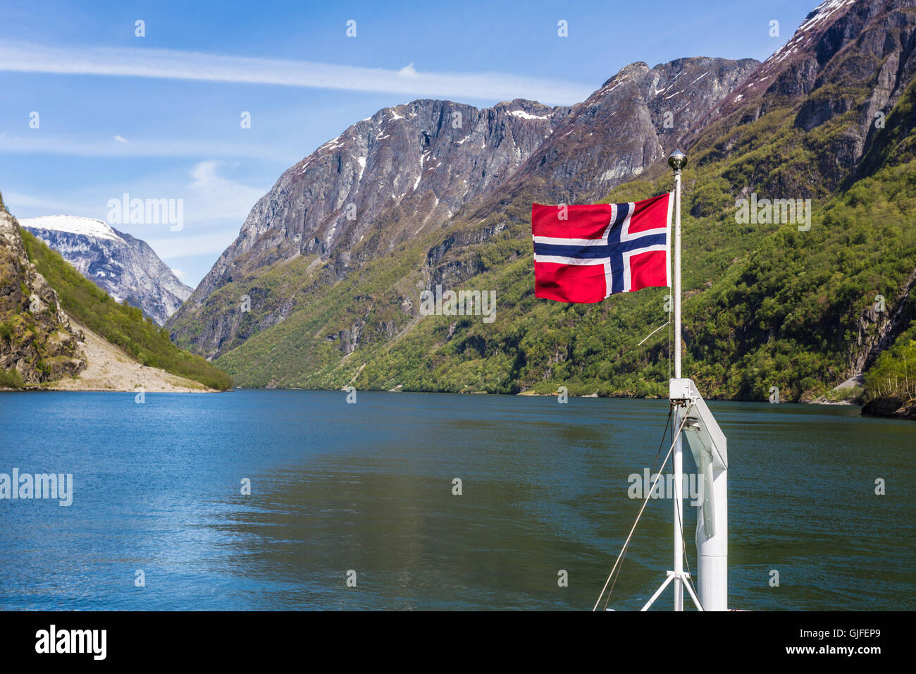 Norwegische Flagge auf der Rückseite eine Baot Segeln entlang der Sognefjord zwischen Flåm und Gudvangen. Stockfoto