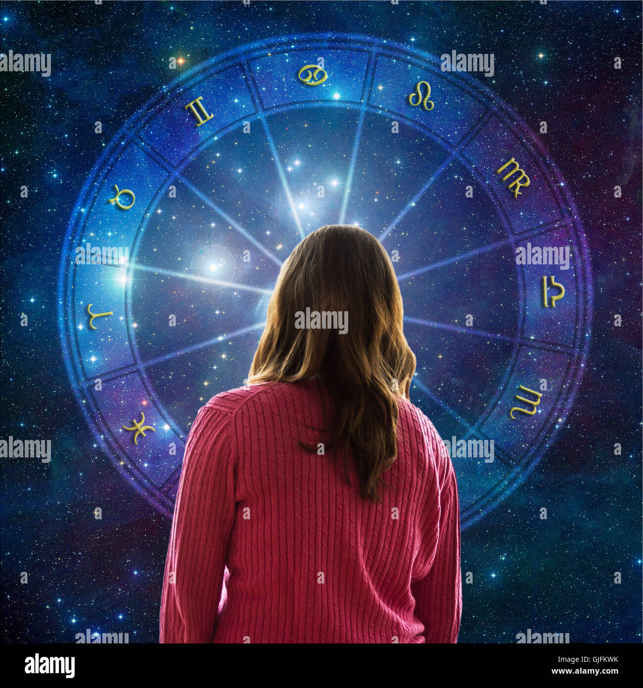 Frau vor einem Astrologie Horoskop mit alle Tierkreiszeichen Stockfoto
