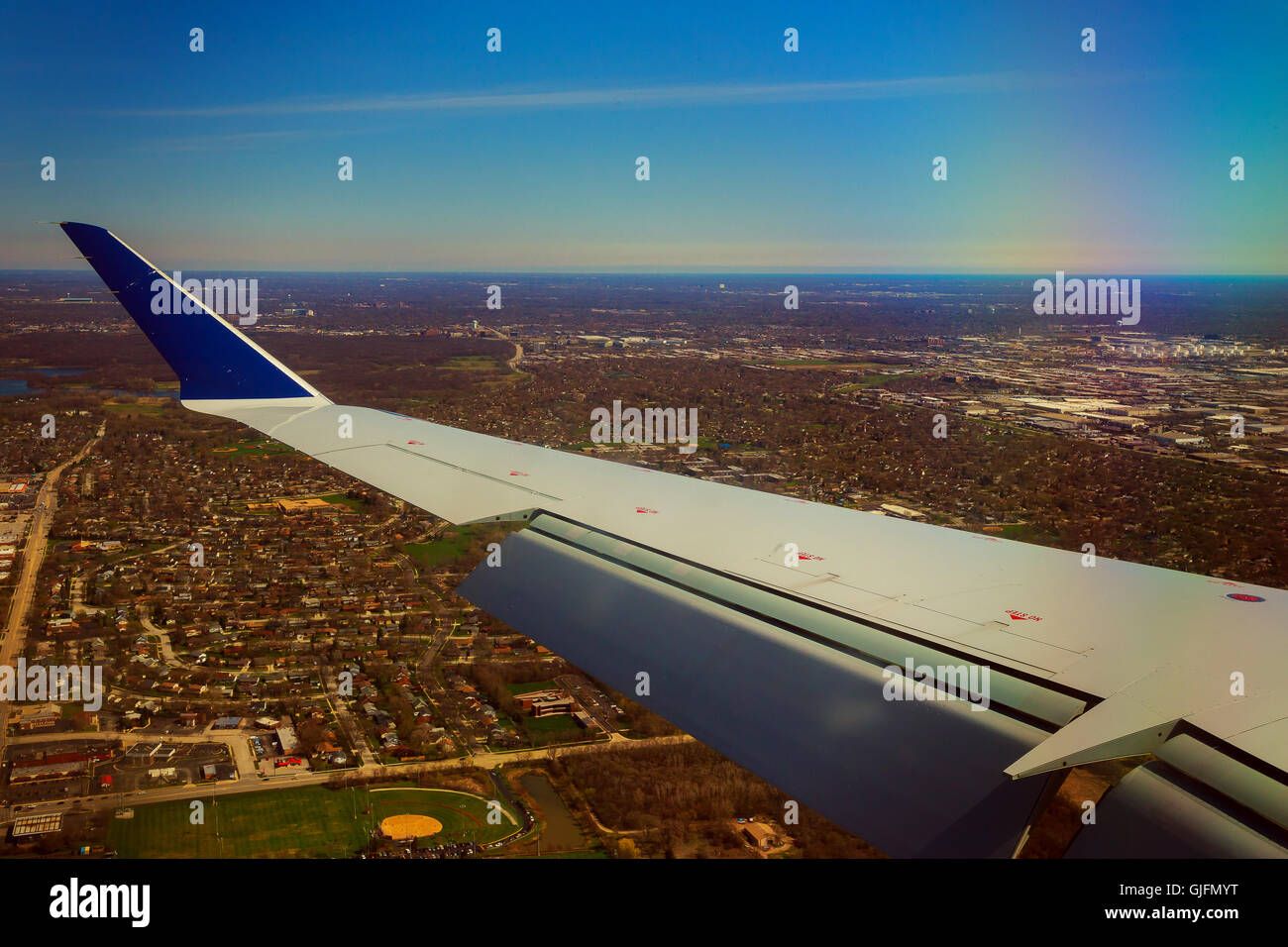 Flügel eines Flugzeugs fliegen über den Wolken und Boden Stockfoto