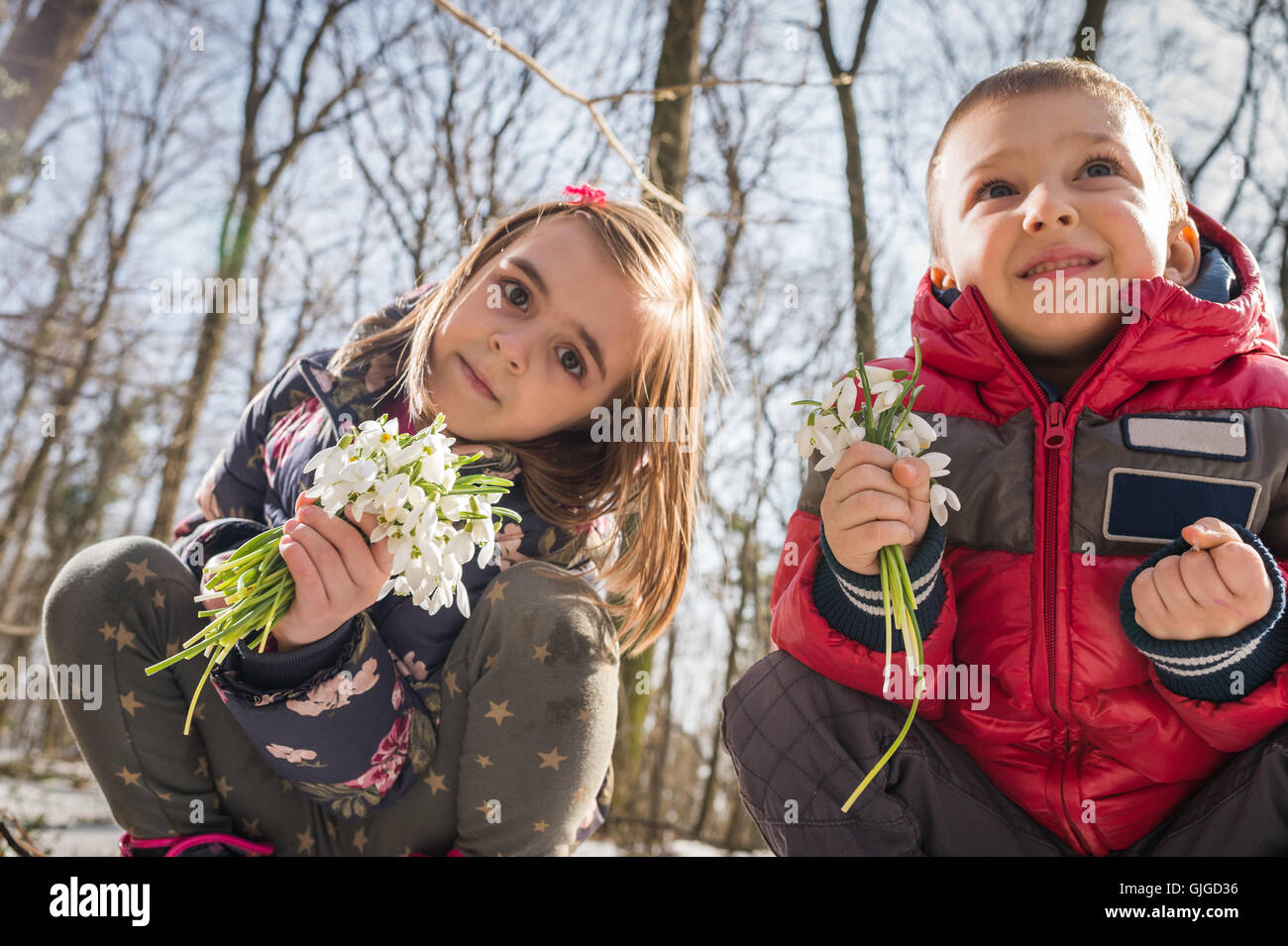 Jungen und Mädchen pflücken Blumen des Frühlings Stockfoto