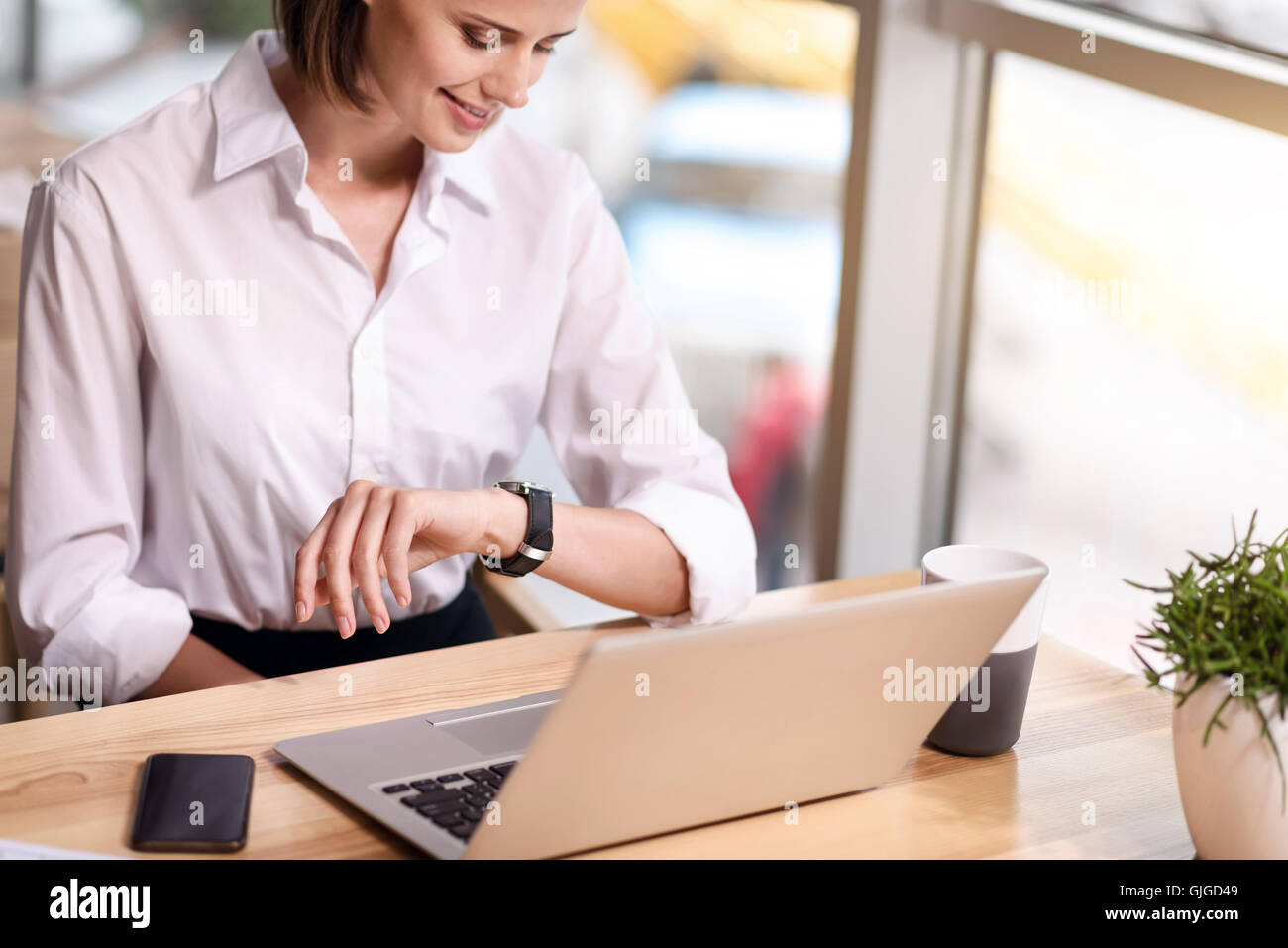 Angenehme Inhalt Frau am Tisch sitzen Stockfoto