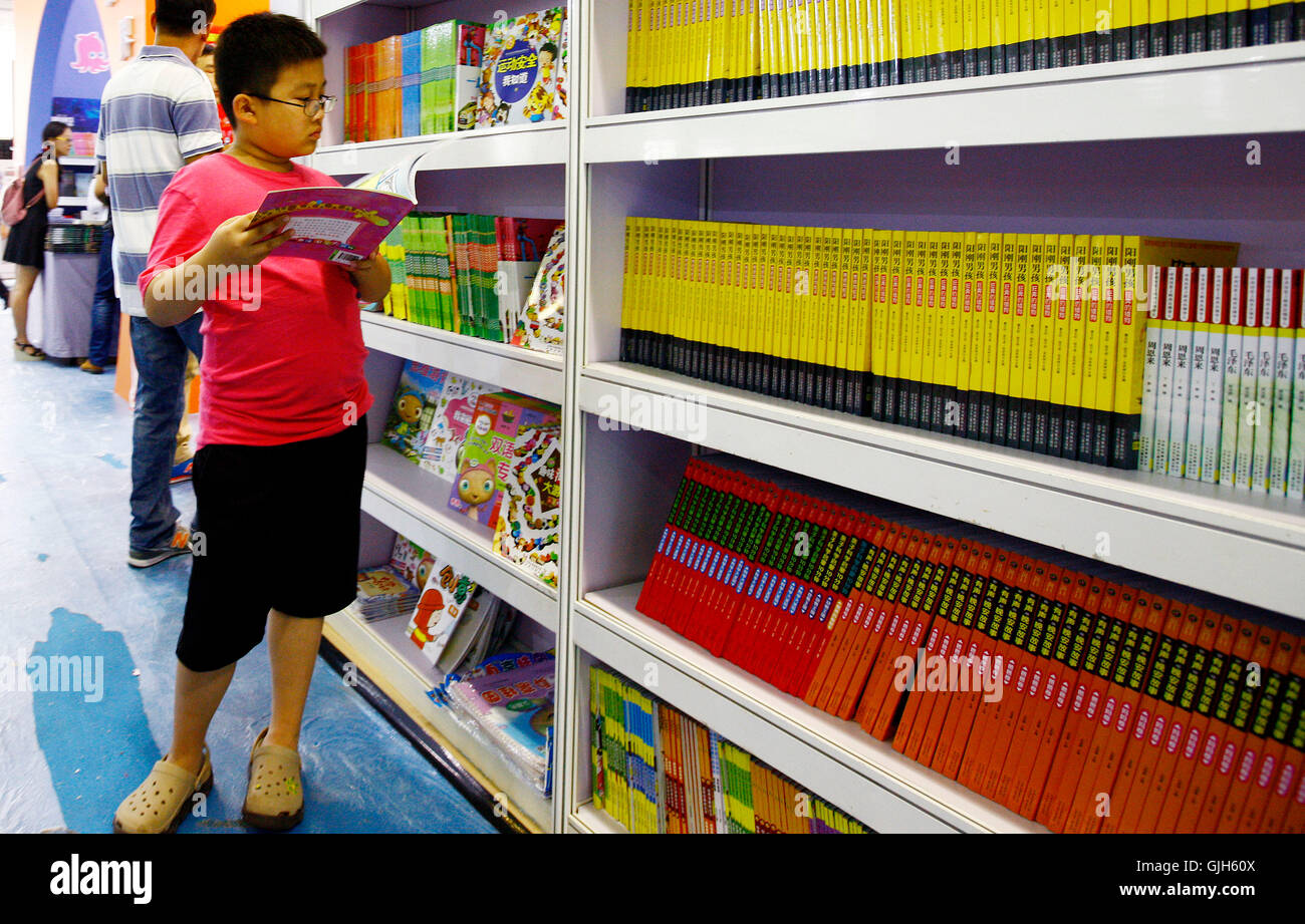 Shanghai. 17. August 2016. Ein Kind liest ein Buch auf der 2016 Shanghai Buchmesse in Ost-China Shanghai, 17. August 2016. Kinder, die im Urlaub Tauchen in die Welt der Bücher auf der Buchmesse. © Fang Zhe/Xinhua/Alamy Live-Nachrichten Stockfoto