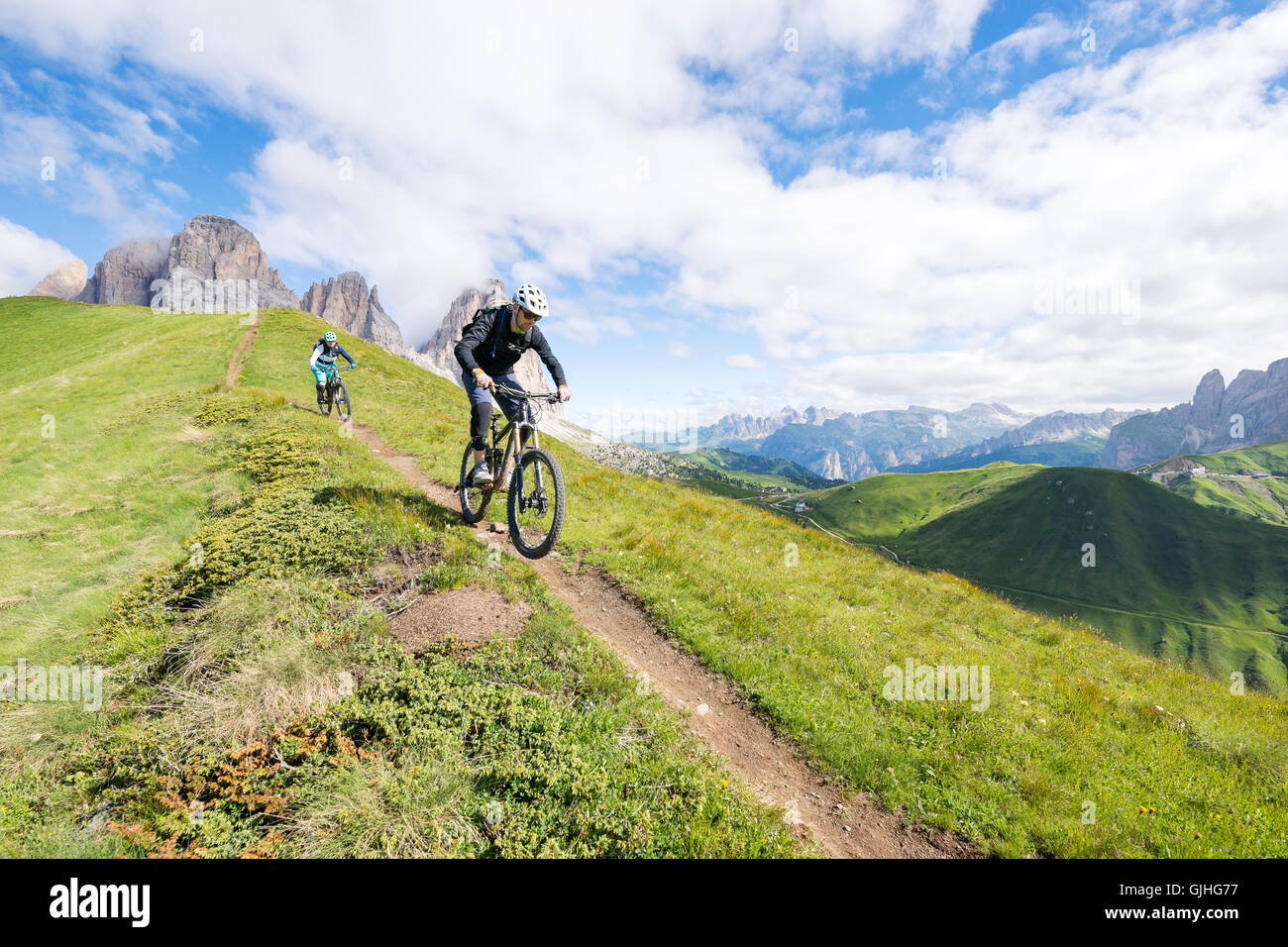 Mann und Frau Mountainbiken entlang Trail, Dolomiten, Italien Stockfoto