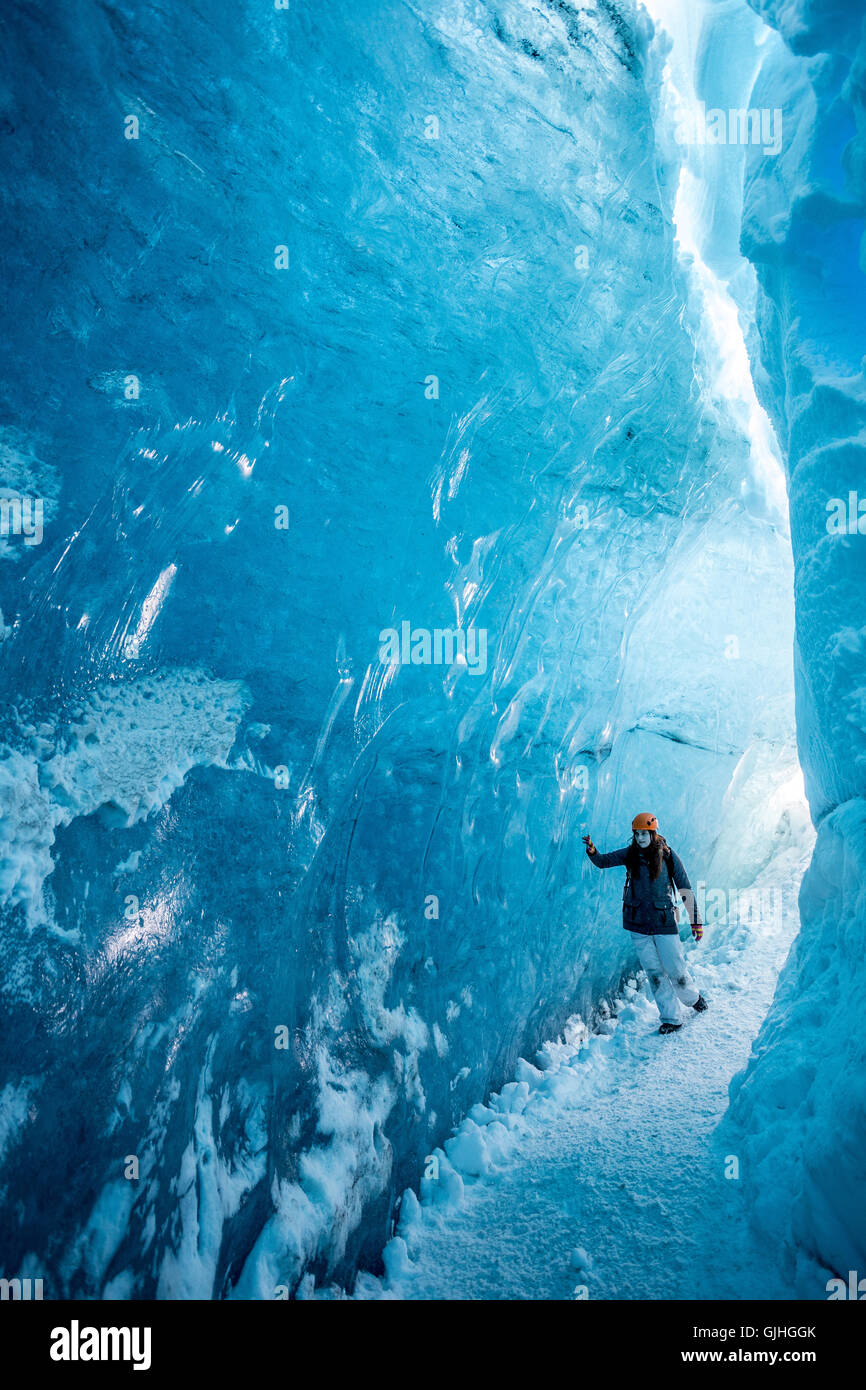 Frau zu Fuß durch Gletschereis Höhle, Island Stockfoto