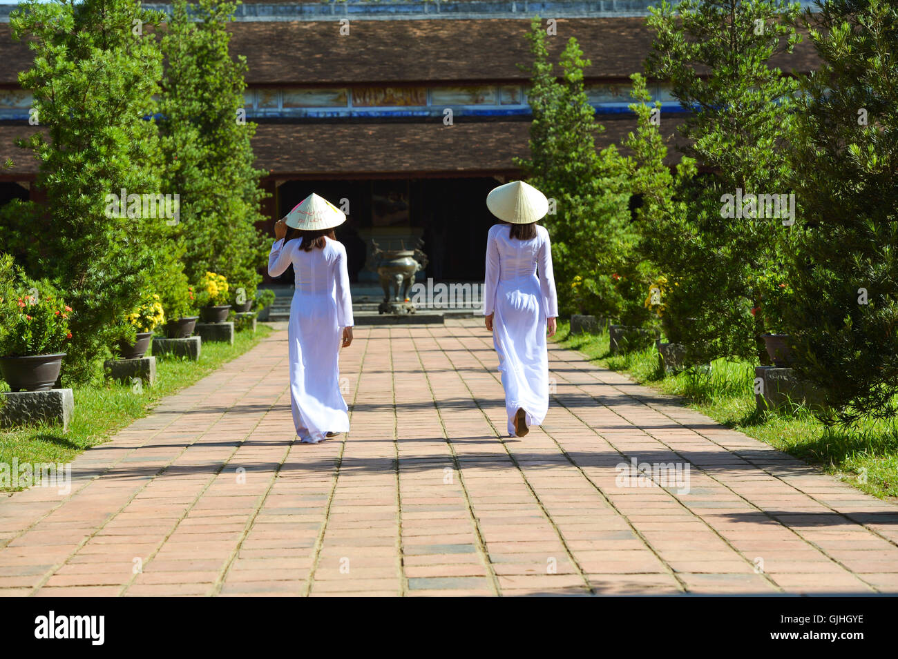 Rückansicht der beiden Frauen, die zu Fuß in Richtung einer Pagode, Hoi an, Vietnam Stockfoto