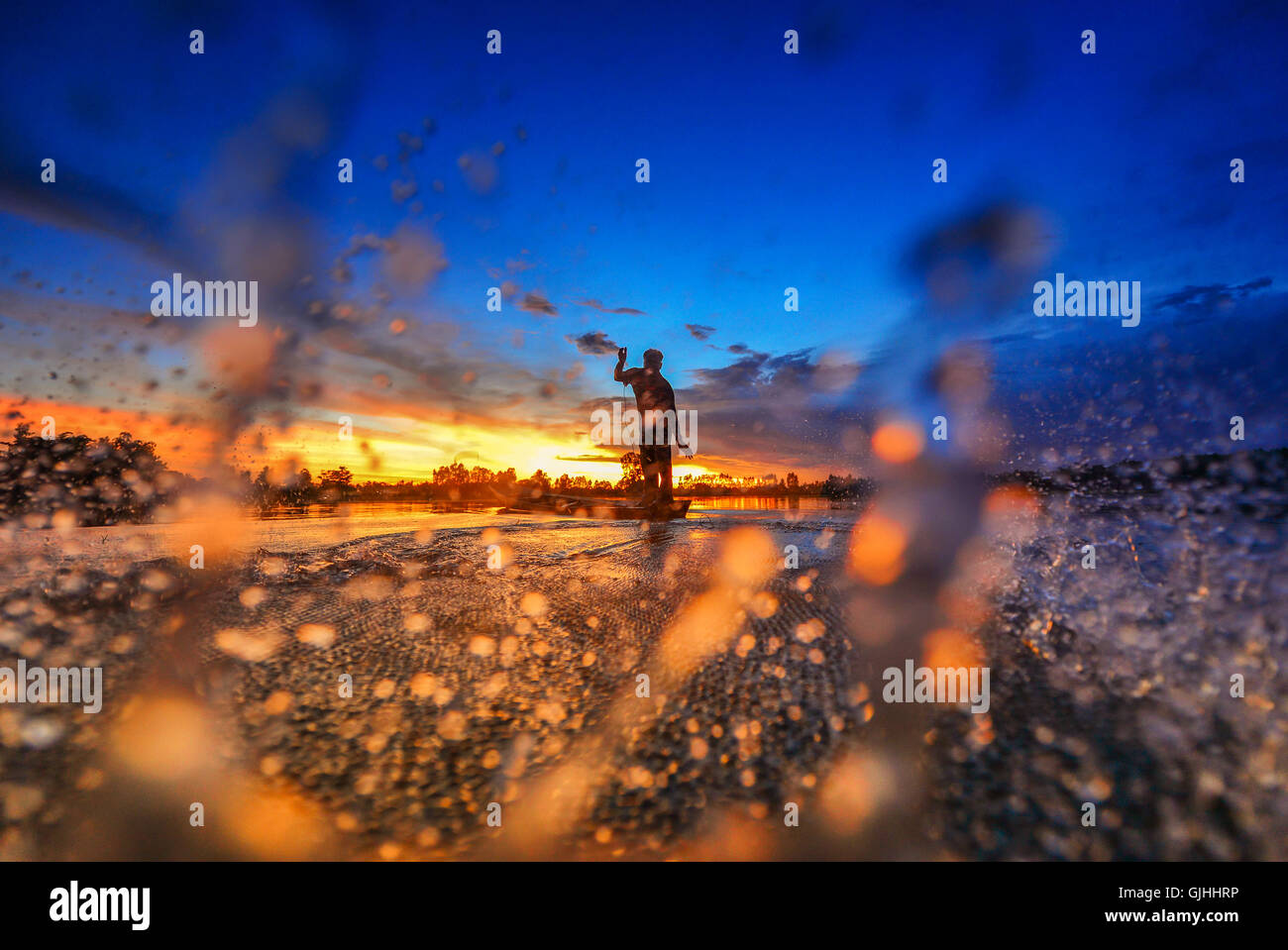 Fischer Casting Fischernetz bei Sonnenuntergang, Thailand Stockfoto