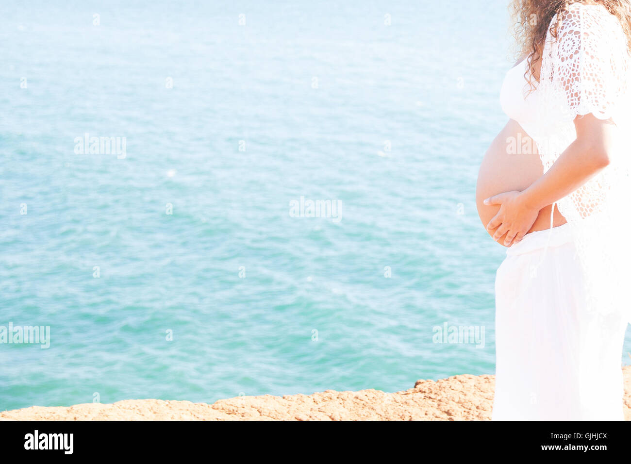 Porträt einer schwangeren Frau, stehend auf dem Seeweg Stockfoto