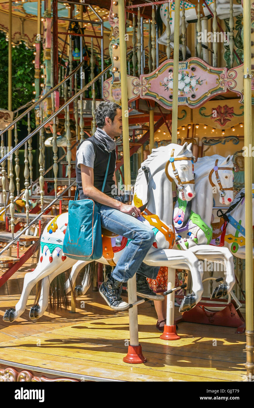 Mann reitet ein Carouselle in Paris, Frankreich. Ca. 2009. Stockfoto