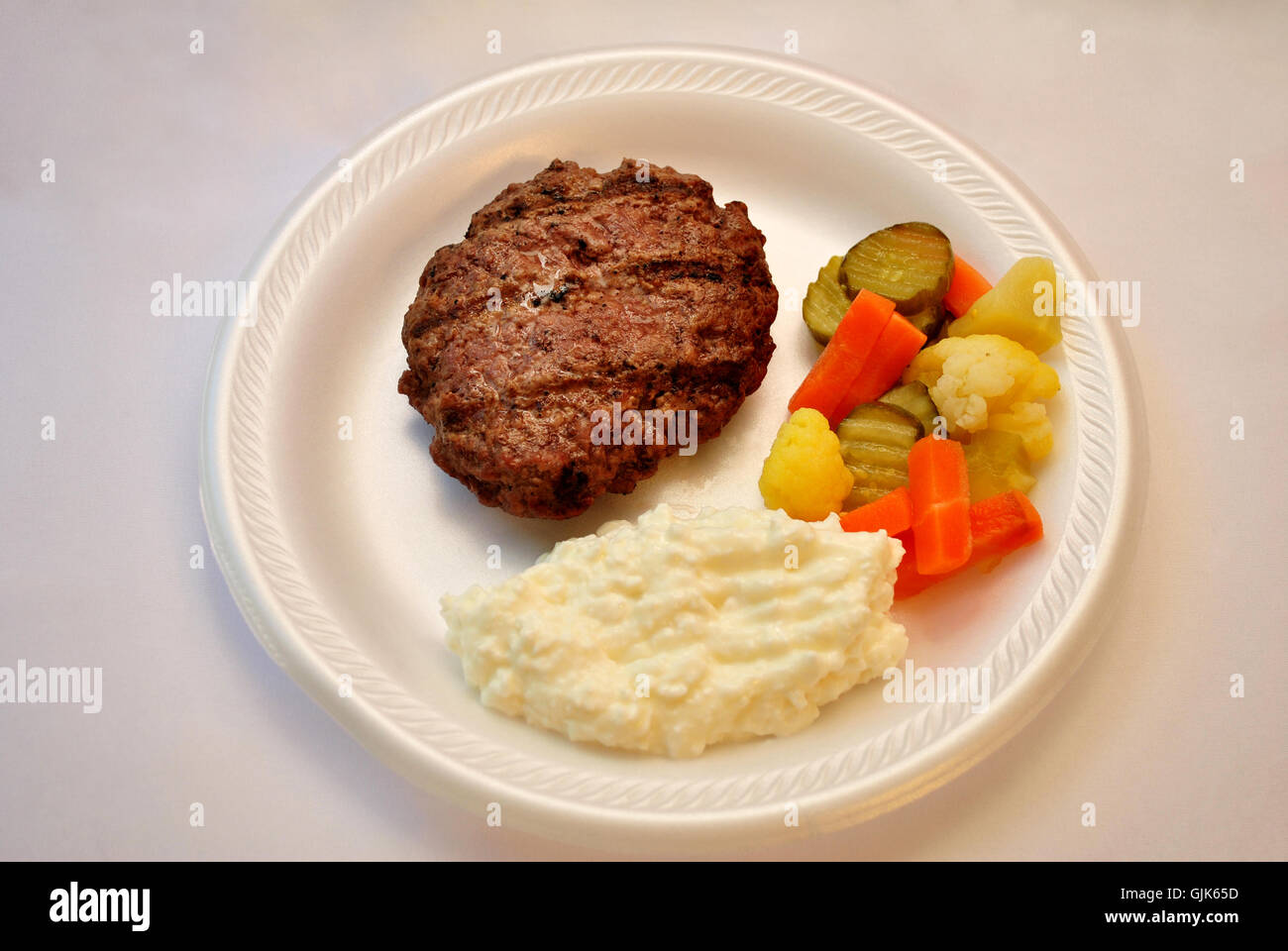 Gesunde Mahlzeit von magerem Fleisch, eingelegtem Gemüse und Quark Stockfoto