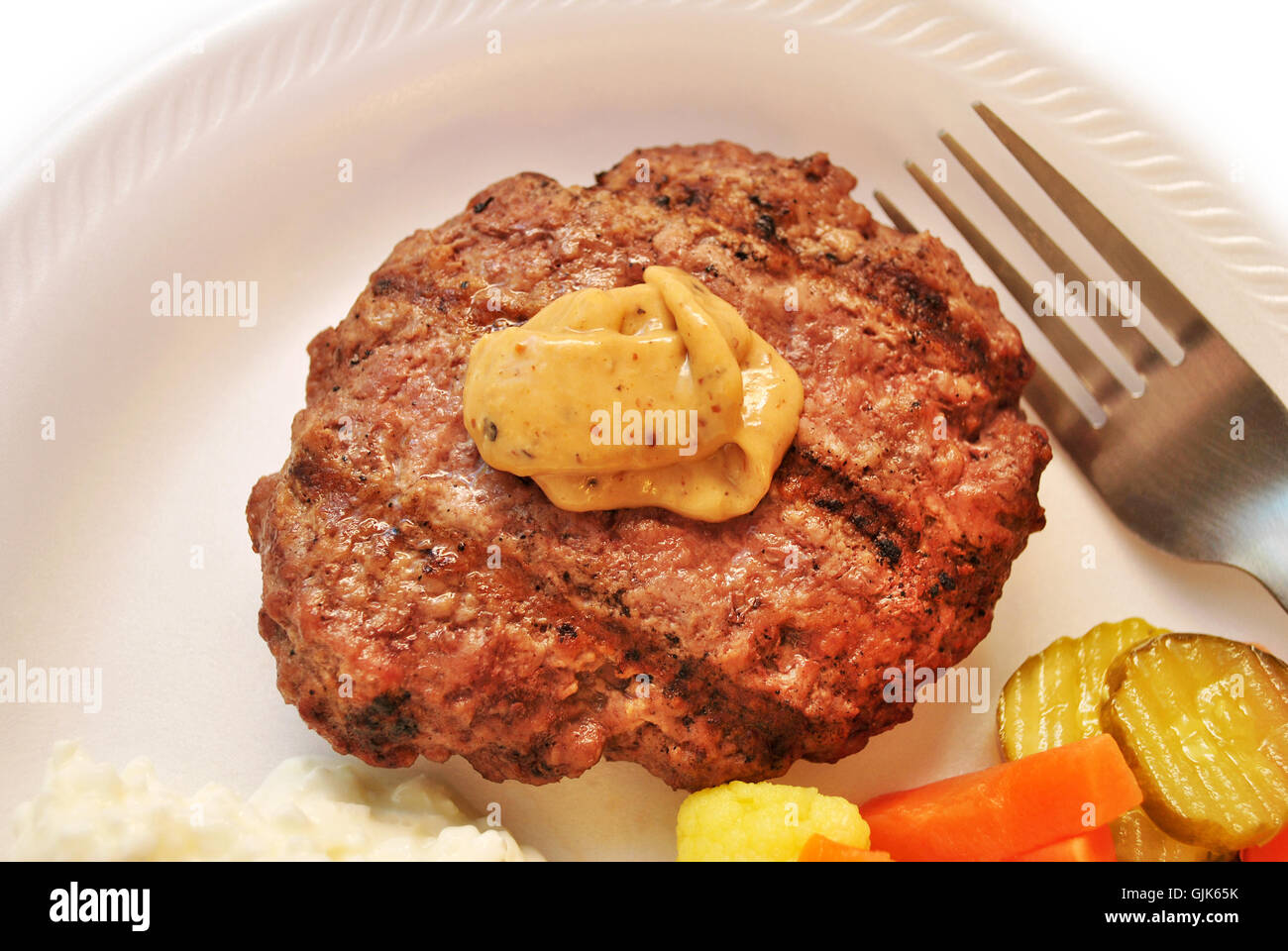 Gegrilltes mageres Burger gekrönt mit würzigen Senf Stockfoto