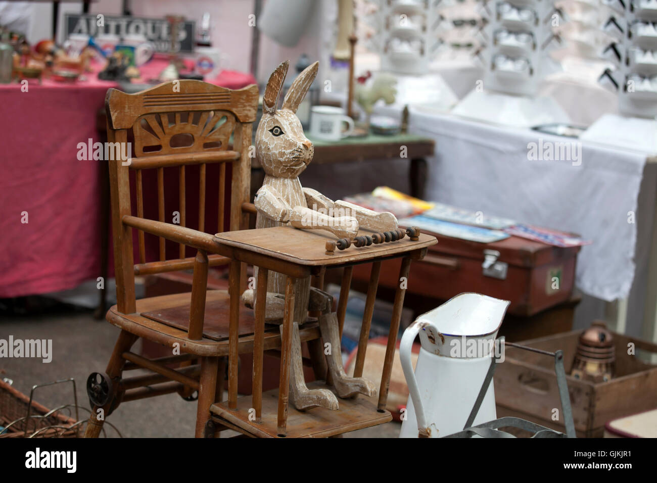 London, UK - 17. Juli 2016.  Spitalfields Antic Market. hölzerne Hase sitzt in einem alten Sessel für die Ernährung von Kindern auf die staatlich Stockfoto