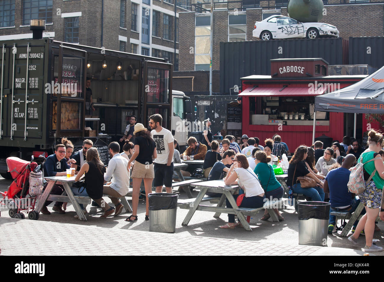 eine bunte Menge von East London außerhalb der Kneipe ein Bier trinken. Stockfoto