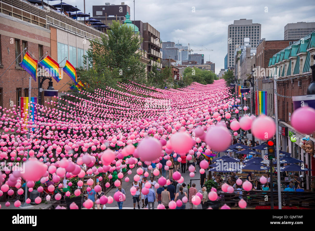 Montreal, CA - 14. August 2016: Rosa Kugeln über Rue Sainte Catherine im Gay Village von Montreal mit schwulen Regenbogenfahnen Stockfoto