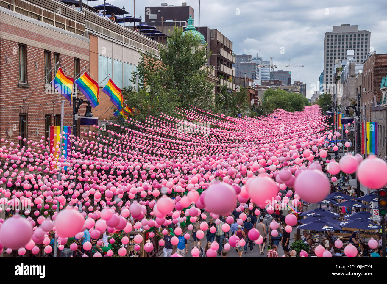 Montreal, CA - 14. August 2016: Rosa Kugeln über Rue Sainte Catherine im Gay Village von Montreal mit schwulen Regenbogenfahnen Stockfoto