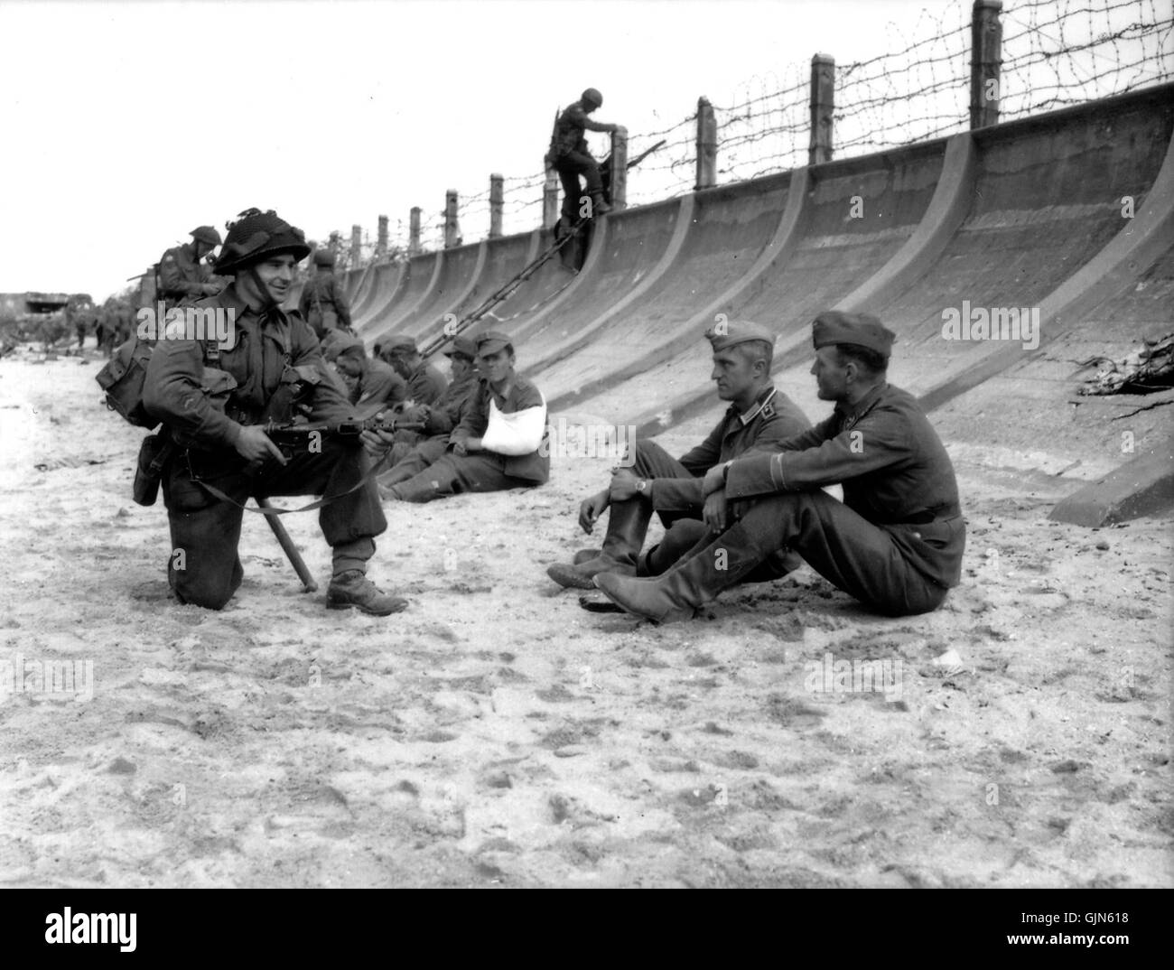 Dieses Bild zeigt wahrscheinlich deutsche Kriegsgefangene am Juno Beach, Normandie, während oder nach der Landung des D-Day von 1944. Der Strand war einer der wichtigsten Orte der alliierten Invasion Frankreichs. Stockfoto