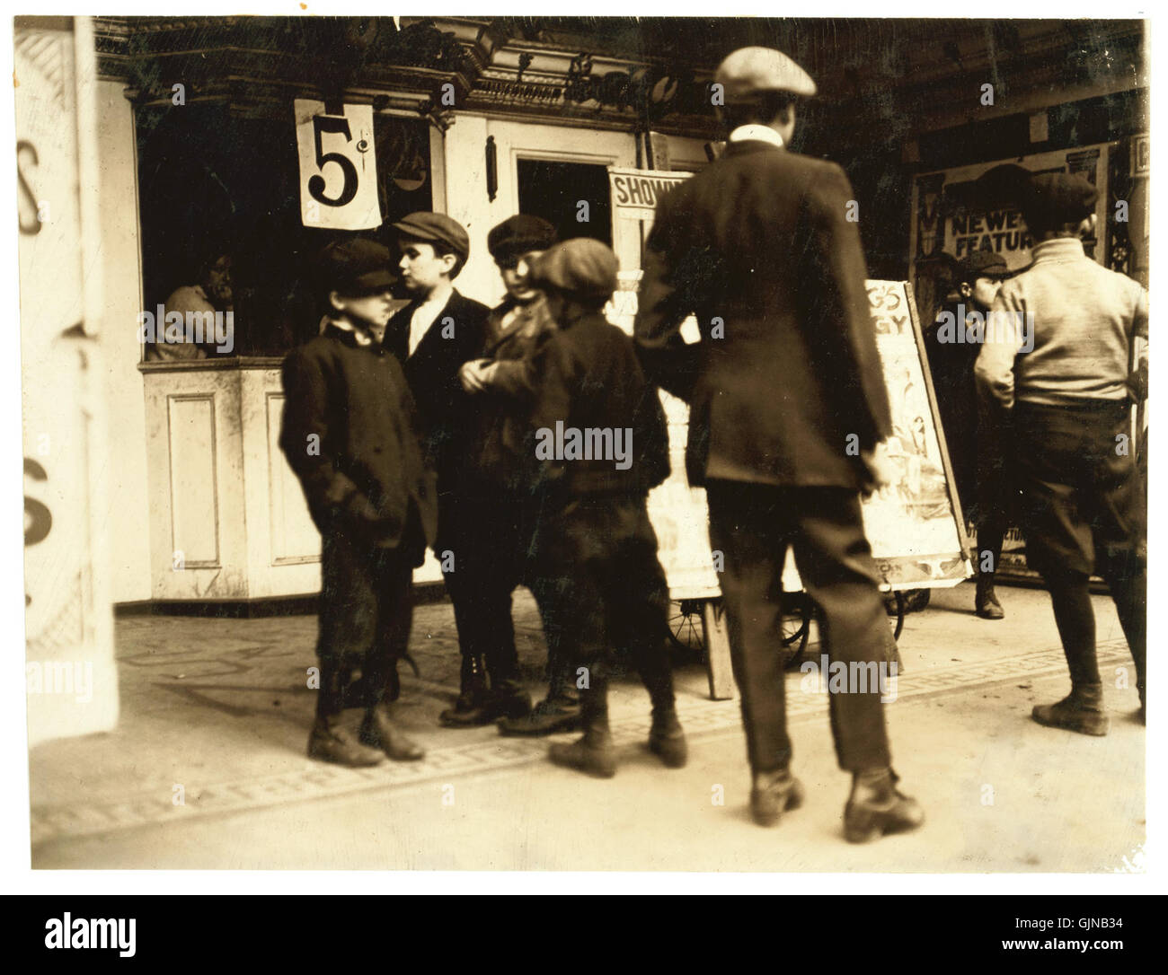 Dieses Foto von Lewis Hine mit dem Titel „Going to the Movies“ zeigt die Szene des frühen 20. Jahrhunderts in Jersey City, New Jersey, und zeigt Kinder, die in ein Kino gehen. Es spiegelt das wachsende Interesse der Zeit am Kino und dem gesellschaftlichen Leben der Zeit wider. Stockfoto