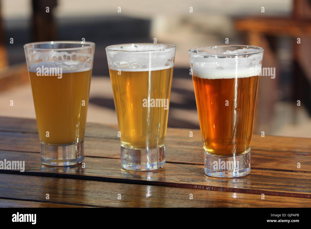 Eine Auswahl an drei Craft Biere während einer Degustation auf einem Holztisch Stockfoto
