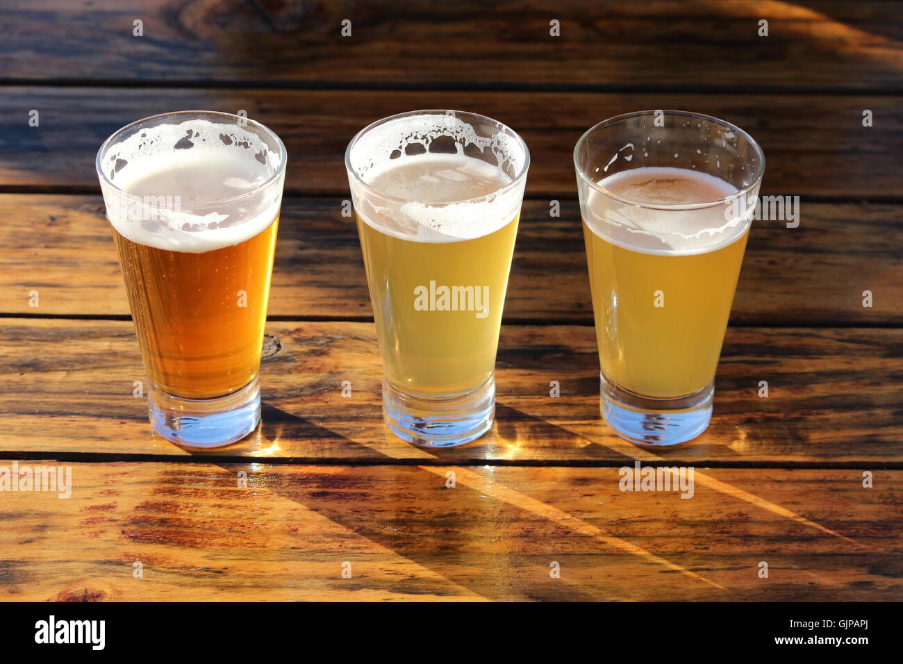 Eine Auswahl an drei Craft Biere während einer Degustation auf einem Holztisch Stockfoto
