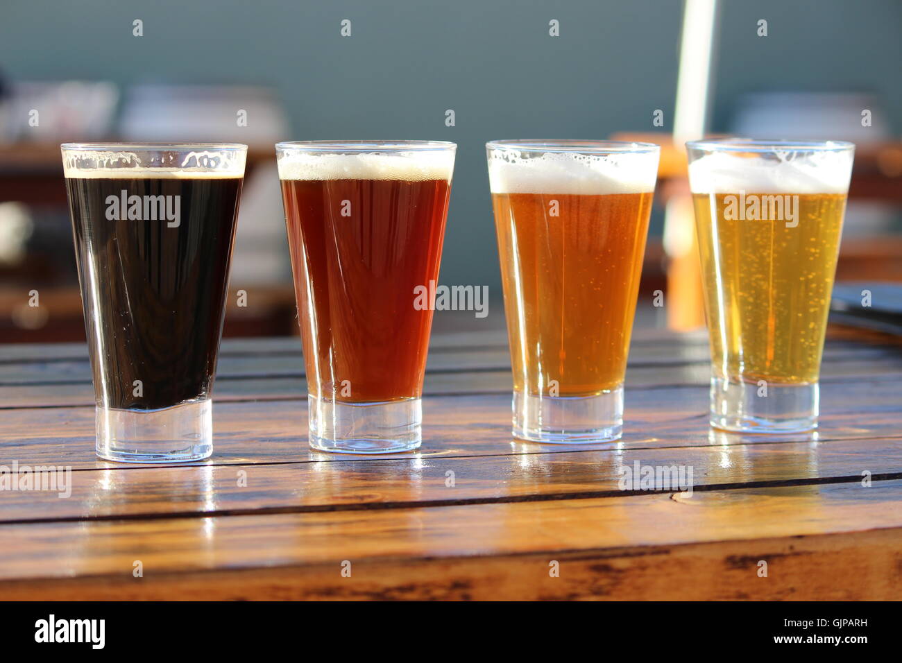 Eine Auswahl von vier Craft Biere während einer Degustation auf einem Holztisch Stockfoto