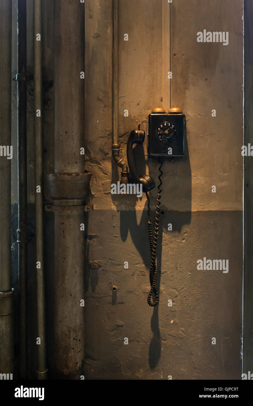 Eine alte schwarze Telefon hängt an der Wand in einer Werkstatt Stockfoto