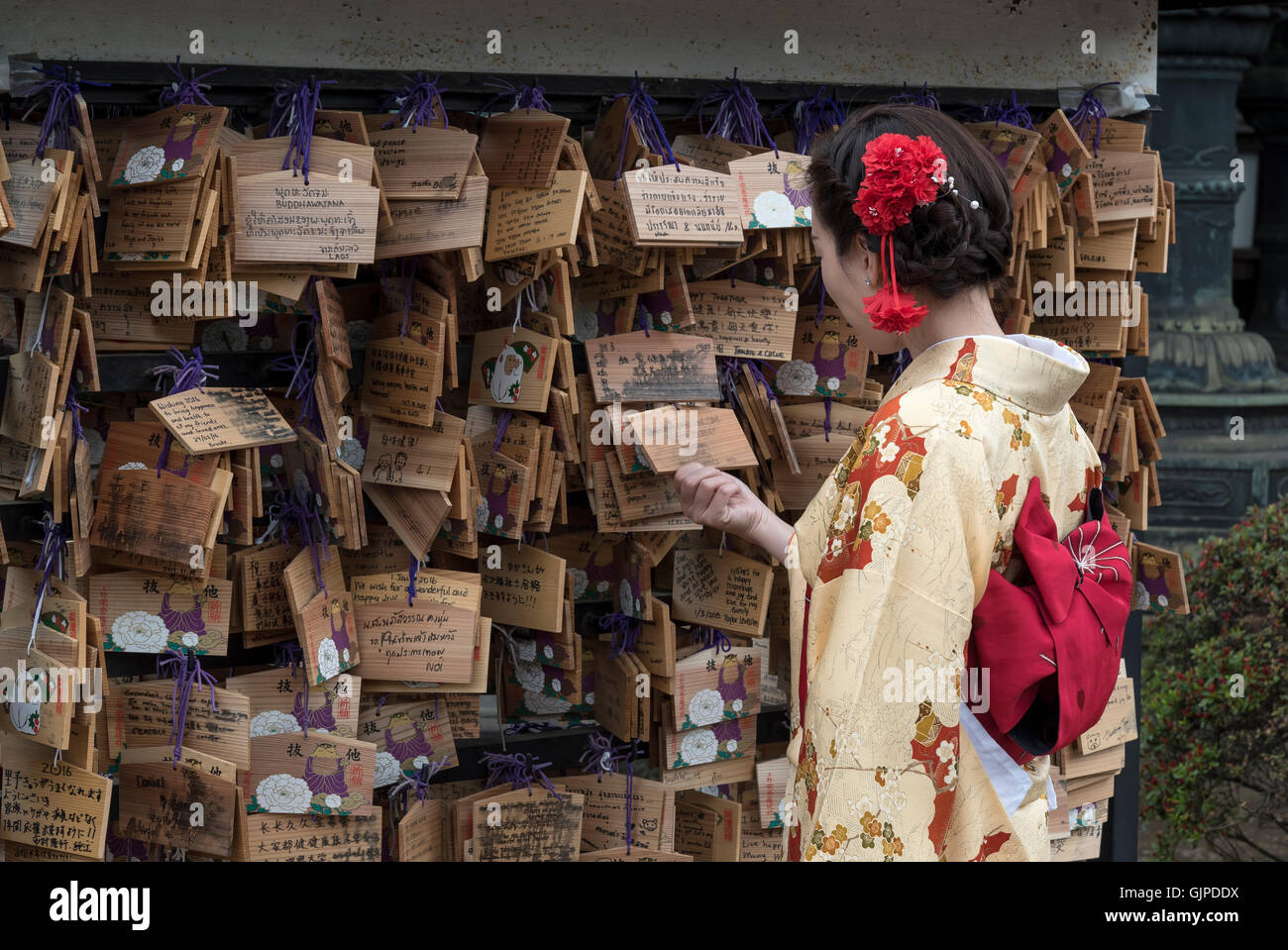 Frau, gekleidet in traditionellen Kimono befasst sich mit Ema Wunsch Plaketten in Ueno Geschichtliches, Tokyo, Japan Stockfoto