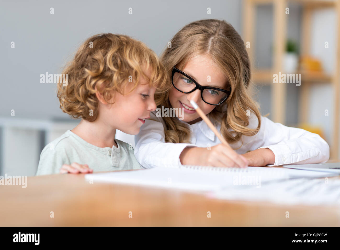 Mädchen schreiben während Bruder sah es Stockfoto