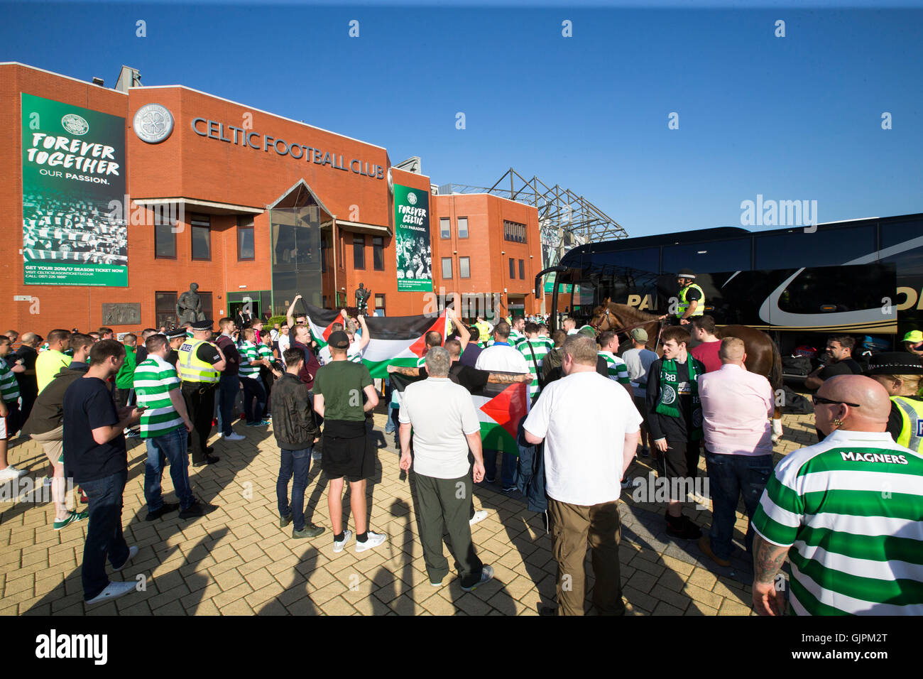 Fans halten eine palästinensische Flagge als der keltische Trainer während der UEFA Champions League-Qualifikation Play-off, ersten Bein Match im Celtic Park, Glasgow kommt. Stockfoto