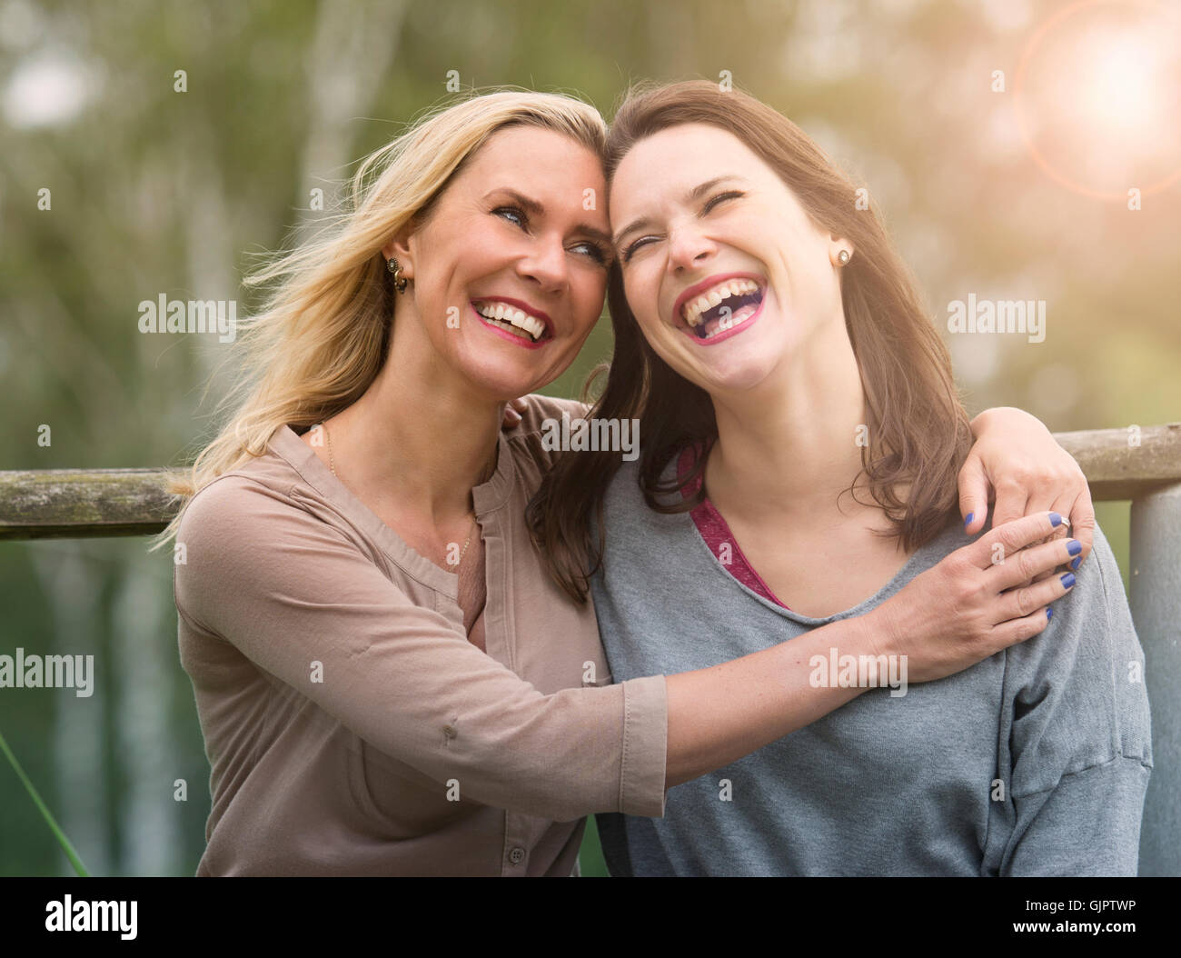 zwei Frauen umarmten einander im Freien und lachen Stockfoto