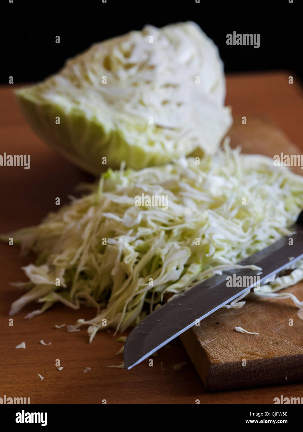 Kohl wird durch Messer auf einem Brett geschnitten. Stockfoto