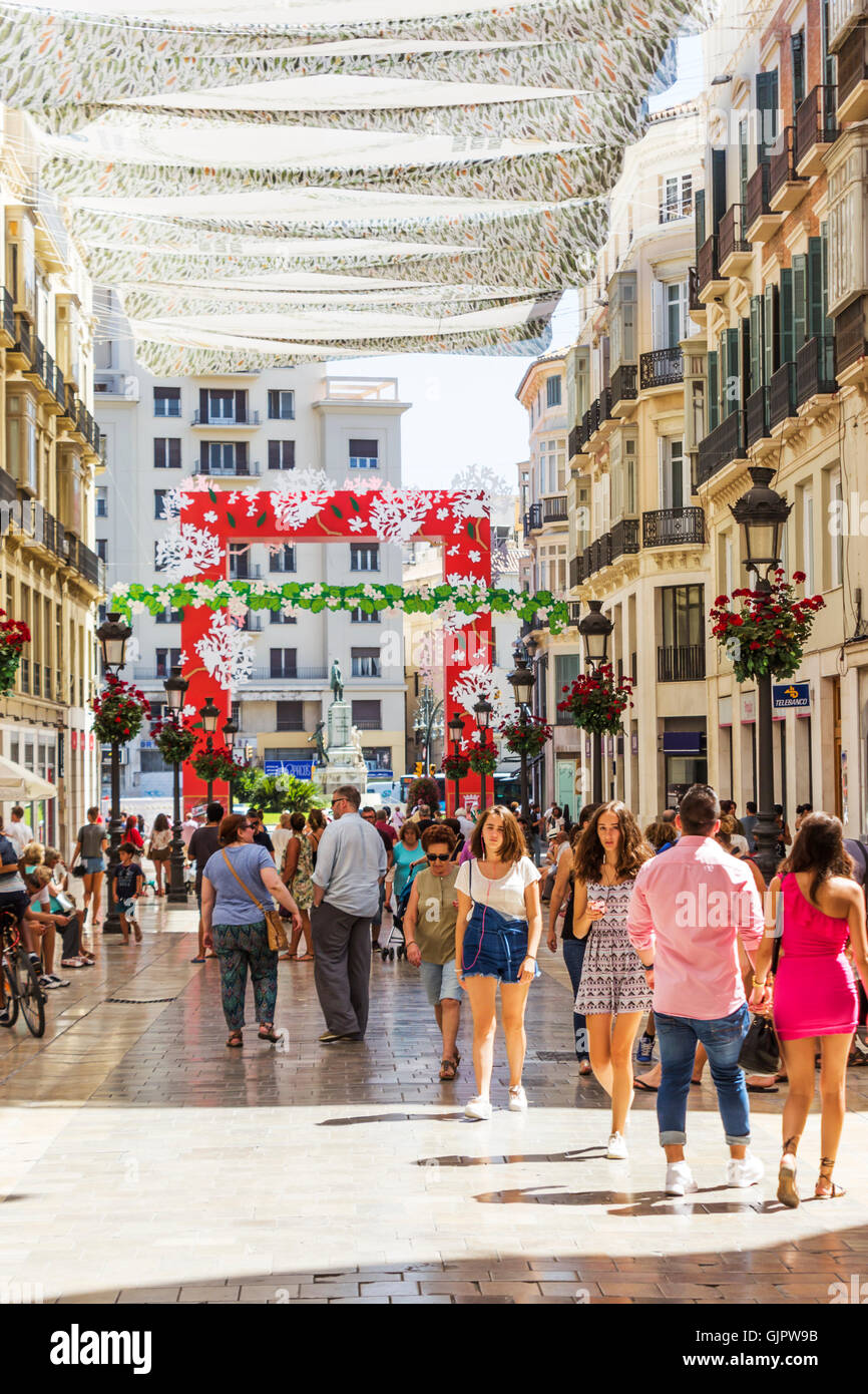 Calle Marques de Larios, Malaga, Costa Del Sol, Andalusien, Spanien.  Fußgänger schlendern Sie unter schattenspendenden Markisen Stockfoto