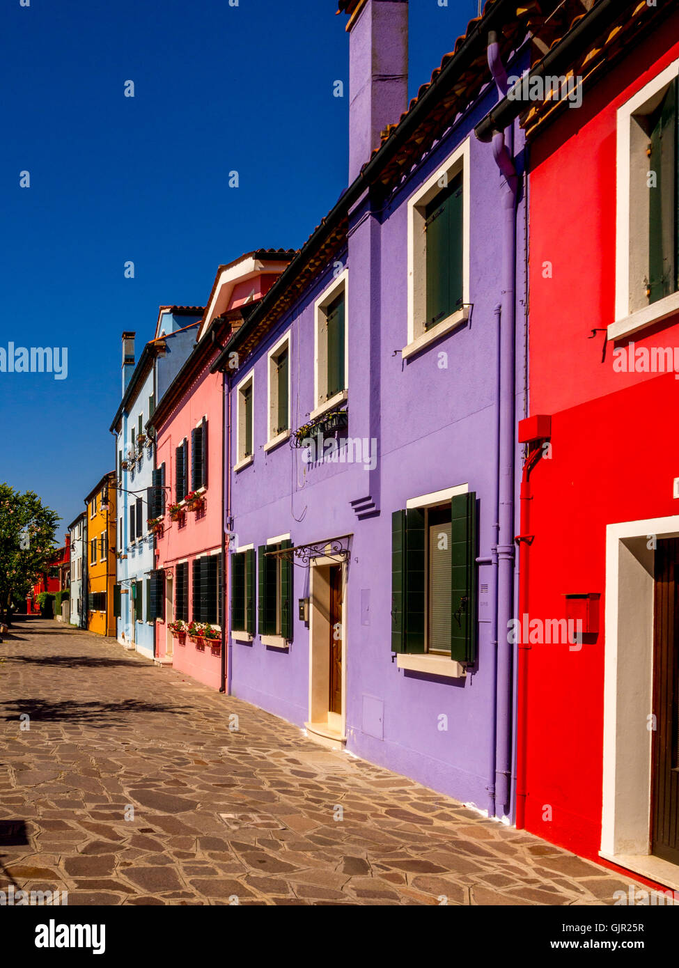 Die traditionell bunt bemalten Häuser auf der Terrasse am Canalside befinden sich auf der Insel Burano. Venedig, Italien. Stockfoto