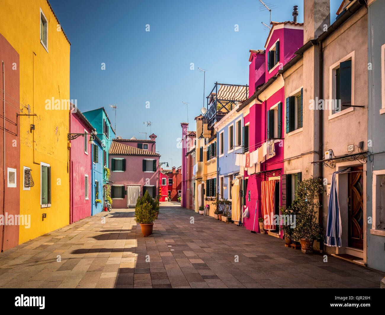 Traditionelle bunt bemalte Terrassenhäuser mit Waschküche, die draußen an Wäscheleinen hängt, auf der Insel Burano. Italien Stockfoto