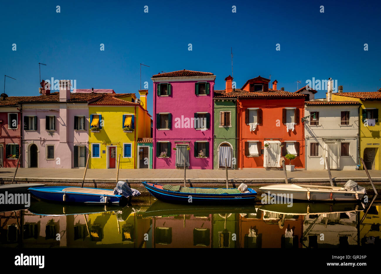 Die traditionell bunt bemalten Häuser auf der Terrasse am Canalside befinden sich auf der Insel Burano. Venedig, Italien. Stockfoto