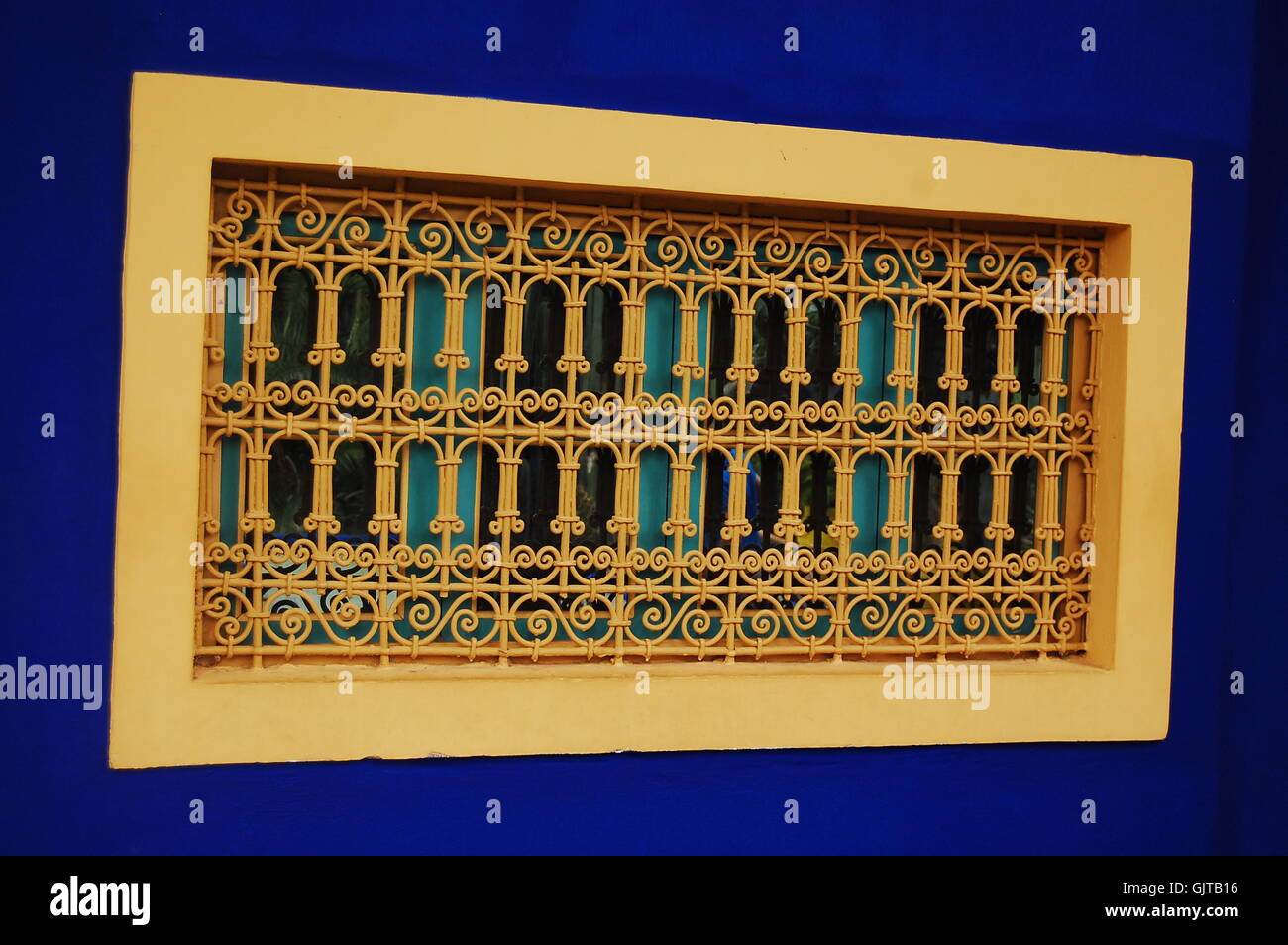 Eine prunkvolle Stück Metall durch eine Wand gemalt Dunkelblau umgeben. Stockfoto