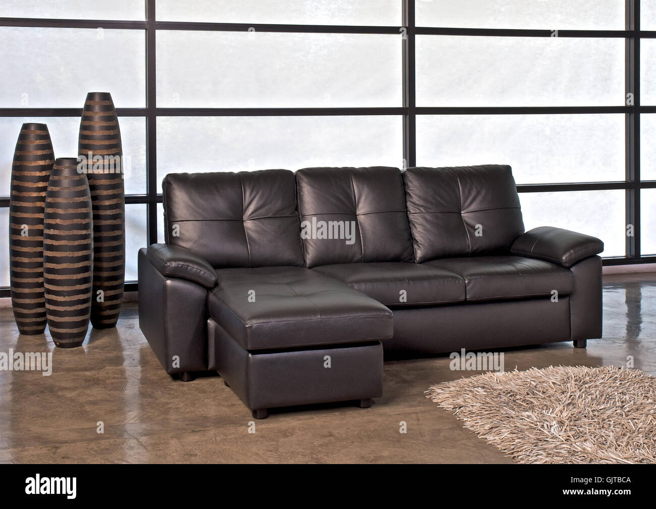 Braune Leder-Sofa mit Hocker für Zuhause oder im Büro Stockfotografie -  Alamy